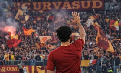 Un giocatore di spalle saluta la curva sud della Roma