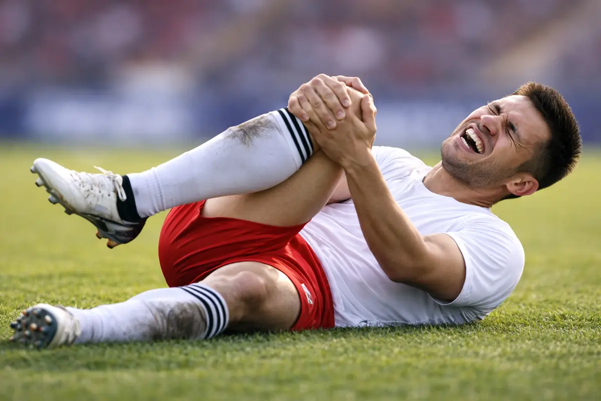 Rottura del crociato e del menisco: che sfortuna per la Juventus 26 Giocatore infortunato a terra che si tiene il ginocchio